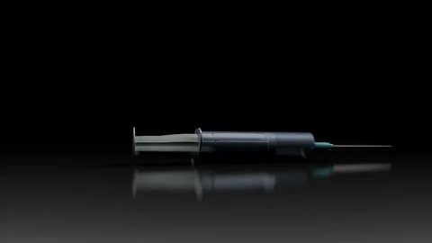 Model of a disposable plastic syringe rotates slowly on a black background. medi Stock Footage 155565835