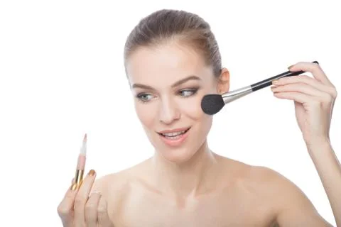 Model doing her makeup, isolated on a white background Stock Photos