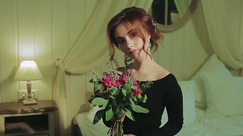 Model With Flowers Stands in Room Stock Footage 75382949