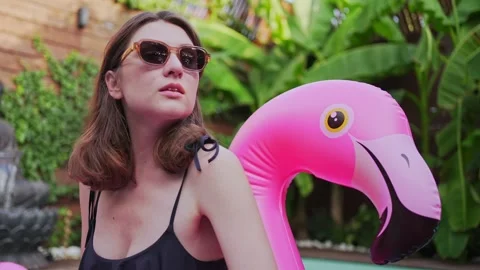 Model in glasses on a pink mattress in the pool. A young woman poses in the Stock Footage 161152609