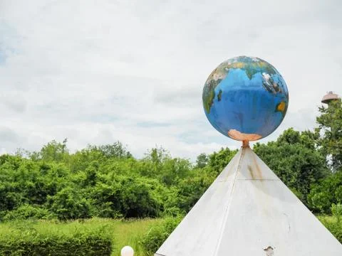 A model globe is placed on a triangular platform. Stock Photos