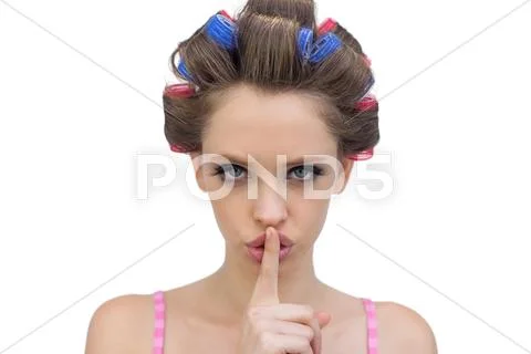 Model in hair rollers posing with finger on mouth Stock Photos