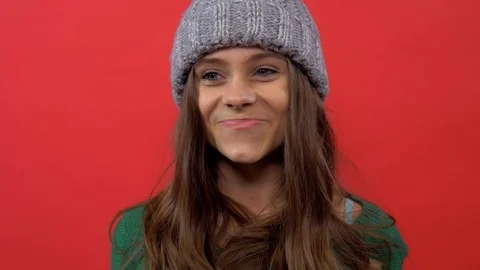 Model in a hat on a red background throws up confetti Stock Footage 109779452