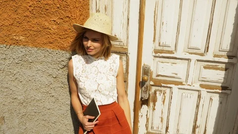 Model Holding Book in Her Hand Leaning Against Wall then Winks and Smiles Video stock 115844825
