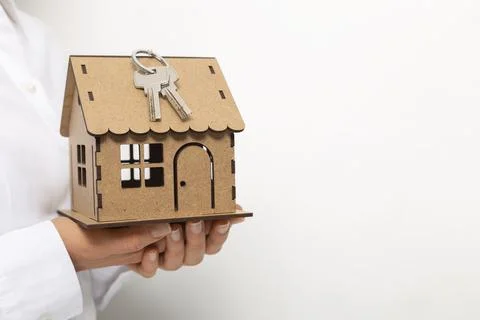 Model house with a key in hands on a white background.  Stock Photos