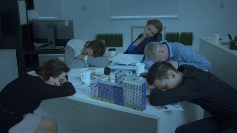 Model of house on table, workmates sit and sleep Stock Footage 121813303