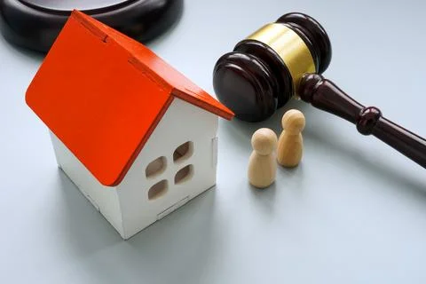 Model of house with two figures and gavel. Separation or inheritance concept. Stock Photos