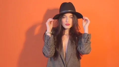 Model in jacket touches the hat and posing during shooting time in studio Stock Footage 73348240