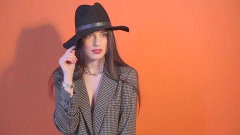 Model in jacket touches the hat and posing Stock Footage 73356304