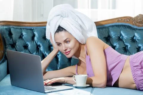 Model with laptop on luxury couch. Model posing in elegant home interior Stock Photos