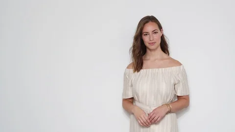 Model Laughing as the Wind Blows Her Hair Inside A Studio with White Background Stock Footage 116915313