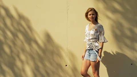 Model leaning on yellow wall 스톡 동영상 107604678