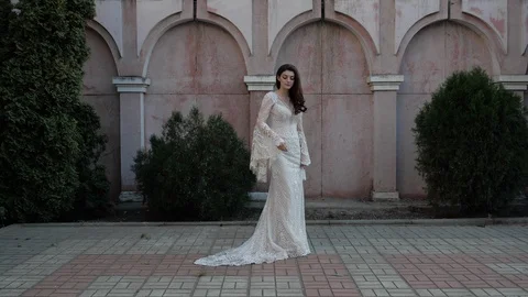 Model in long tight lacy wedding dress poses for camera Stock Footage 126602087