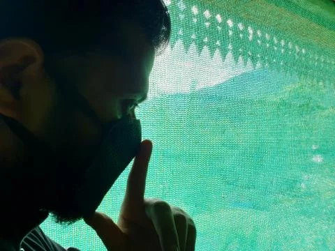 Model looking actor outside through green net. Stock Photos