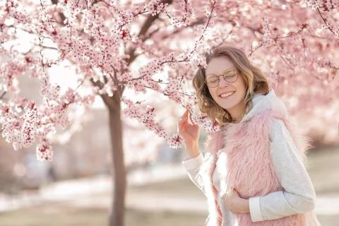 A Model looking at camera, posing in street, near blooming flowers. Female Foto stock
