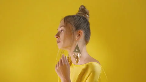 Model looking straight at camera and turns yellow background Stock Footage 275628772