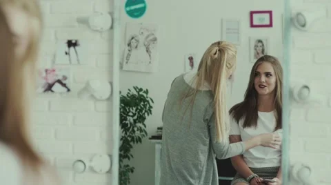 Model looks at herself in the mirror and evaluate the result of the make-up 库存影片 68059195