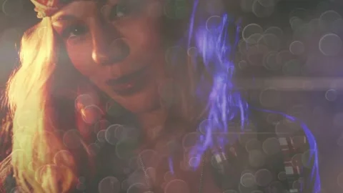 Model lowering gaze, smiling, tilting as lensflare clearing revealing bandana, Stock Footage 333894332