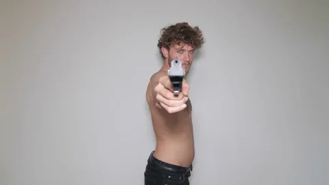 Model male playing with pistol in studio 스톡 동영상 73539902
