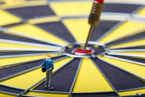 Model mini people walks towards the target on dart board. Stock Photos