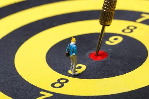 Model mini people walks towards the target on dart board. Stock Photos