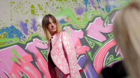 Model with pink dress posing in front of graffiti during a photo session Stock-Footage 59736747