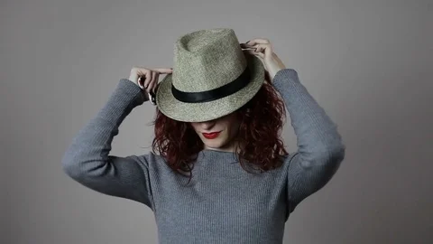 A model is playing with her favorite hat and with her red hair Stock Footage 82039160