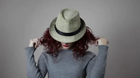 A model is playing with her favorite hat and with her red hair Stock Footage 82043335