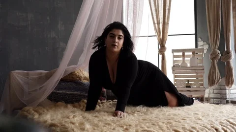 Model plus size with big cheeks and black hair lies almost naked on the bed Stock Footage 106066501