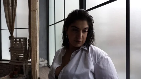 Model plus size drinks juice near the window Stock Footage 106063461