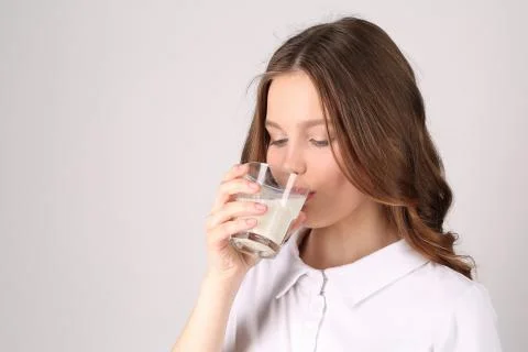 Model in polo drinking milk. Close up. White background Stock Photos