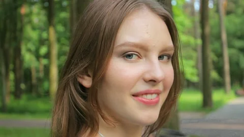 A model poses against a background of trees in sunny weather right Stock Footage 137313604