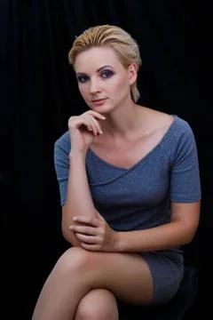The model poses for the camera on a dark background Stock Photos