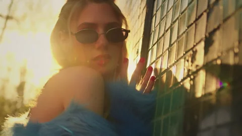 Model poses for the camera near the wall. in a blue fur coat. sunset Stock Footage 302541110