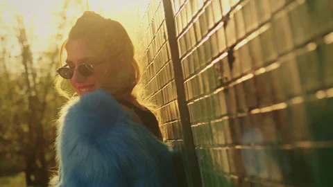 Model poses for the camera near the wall. in a blue fur coat Stock Footage 302541468