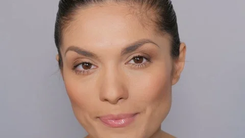 Model poses on camera on white background. Model is smiling and posing on the ca Stock Footage 77333494