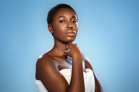 Model poses confidently against a solid blue background, showcasing natural Stock Photos