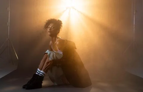 Model posing confidently in dramatic lighting, wearing stylish grunge fashion Stock Photos