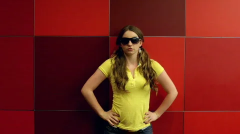 Model posing in front of red square wall Stock Footage 773306