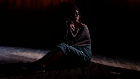 Model is posing sitting on the floor in a dark room Video stock 79628842