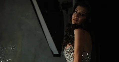 Model posing in the studio. Dramatic picture of pretty woman in sparkling dress Stock Footage 97877939