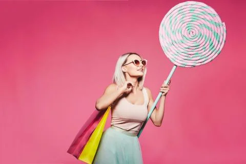 Model posing with with sweets and shopping bags Stock Photos