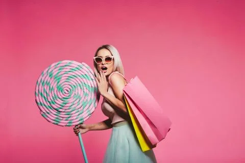 Model posing with with sweets and shopping bags Stock Photos