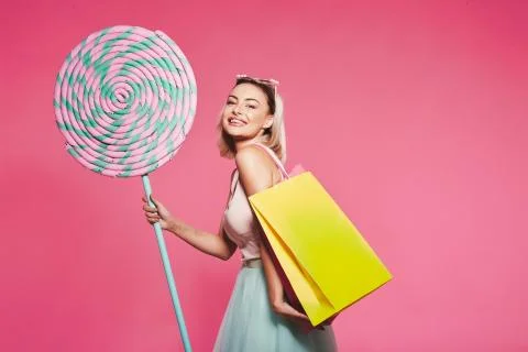 Model posing with with sweets and shopping bags Stock Photos