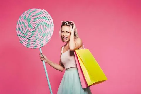 Model posing with with sweets and shopping bags Stock Photos