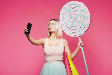 Model posing with with sweets and shopping bags Stock Photos