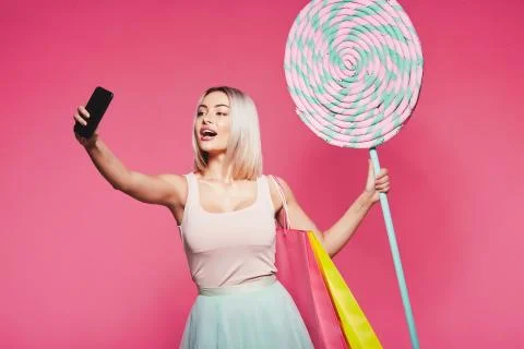 Model posing with with sweets and shopping bags Stock Photos