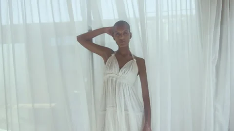 Model posing while standing by curtains and looking straight at camera Stock Footage 275658224