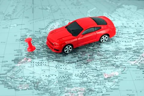Model red car on  background of  geographical map. Concept of travel by car. Fotos de archivo