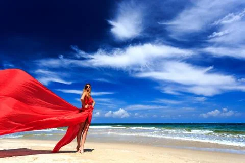 Model in red dress posing on beach Stock Photos